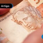 imagem de mão segurando uma nota de cinquenta reais