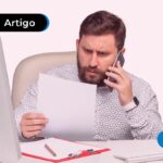 Pessoa no celular olhando para um papel