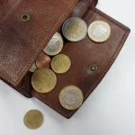 carteira aberta com moedas caindo