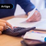 Pessoa segurando papeis e fazendo conta