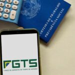 Celular na mesa junto com carteira de trabalho
