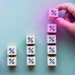 Mesa azul com várias porcentagens e uma mão