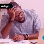 Uma fotografia de um homem pensando e olhando para a tela do notebook.
