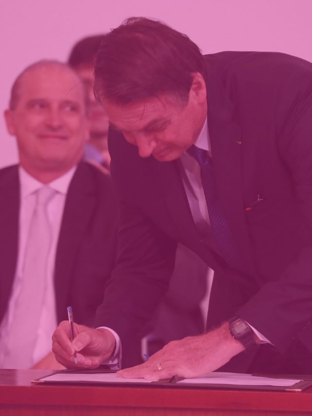 presidente bolsonaro assinando um documento.