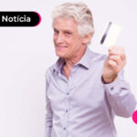 imagem de um senhor segurando um cartão e sorrindo.
