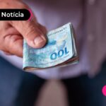 imagem de uma pessoa segurando um bloco de notas de dinheiro.