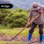 imagem de um homem lavrando um campo com uma enxada