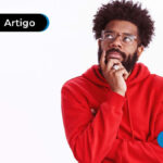 Homem negro de camisa vermelha com uma expressão de pensativo
