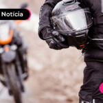 um motoboy segurando um capacete embaixo do braço.