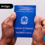 Mãos de um senhor idoso segurando uma carteira de trabalho