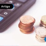 imagem de calculadora sobre a mesa e ao lado algumas moedas douradas