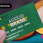 Pessoa segurando o cartão do Auxílio Brasil