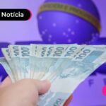 Pessoa segurando varias notas de cem reais