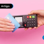 imagem de mão segurando cartão de crédito próximo a máquina de crédito