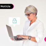 Senhora de cabelos brancos com computador em mãos