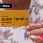 Pessoa segurando o cartão escrito bolsa familia