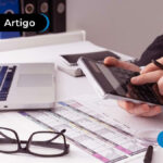 pessoa com calculadora, óculos e notebook