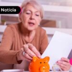 senhora colocando moeda em um cofre com papel na mão