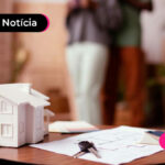 mini casa e papéis em uma mesa