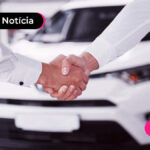 duas pessoas dando a mão e um carro atrás