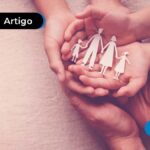 Mãos segurando a representação de uma família feita em papel