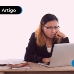 Jovem lendo algo no computador.