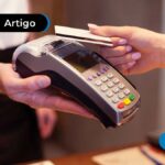 a imagem mostra uma pessoa realizando uma compra com o cartão de crédito.