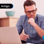 imagem de um homem com um computador ao lado pensando
