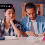Pessoas lendo um papel sob uma mesa