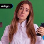 Pessoa segurando um cartão e um celular nas mãos