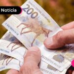 Pessoa contando notas de 200 reais