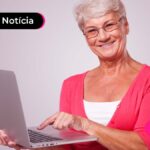 Pessoa a frente de um notebook sorrindo