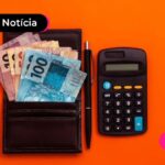 Calculadora e carteira com dinheiro ao lado