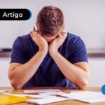 Imagem de homem com expressão de desespero em meio aos papéis