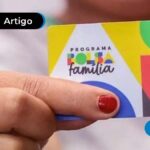 Imagem de pessoa segurando cartão do "Bolsa Família"