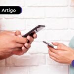 Duas pessoas com celular na mão consultando a restituição do imposto de renda para receber via pix.