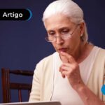 Imagem de pessoa com óculos olhando para a tela de notebook
