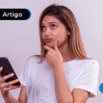 Pessoa pensativa com um celular em mãos