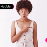 Jovem com expressão de surpresa apontando com o dedo indicador para o lado.