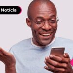 Imagem de pessoa olhando para o celular sorrindo