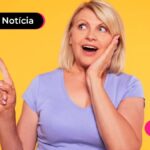 Jovem sorridente com o dedo indicador apontando para cima.