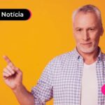 Pessoa com expressão seria e com o dedo indicador apontado para cima.