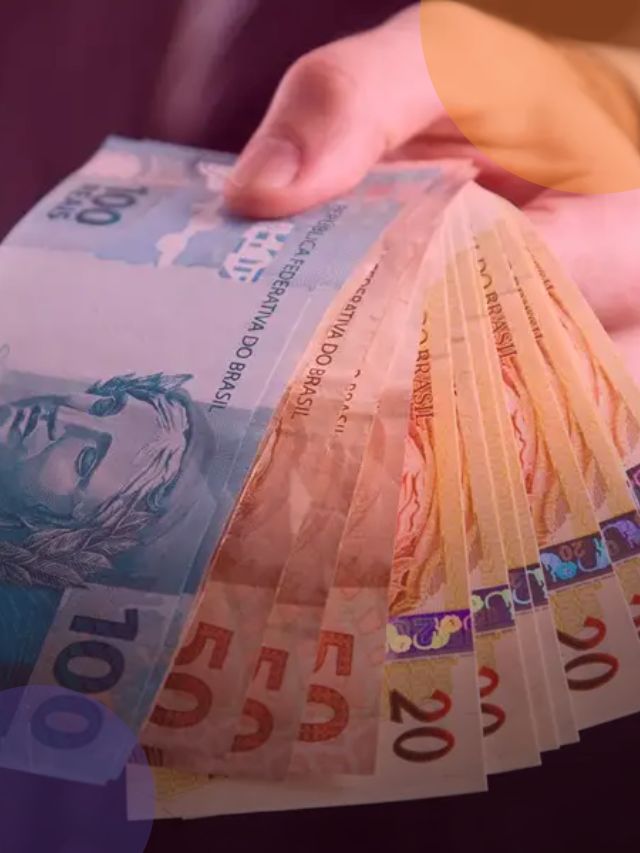 Mão segurando notas de cem, cinquenta e vinte reais.