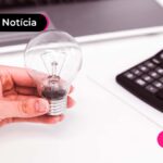 Pessoa segurando uma lâmpada sob uma mesa