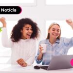 Duas pessoas a frente de um notebook comemorando