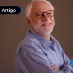 Pessoa de idade sorrindo com os braços cruzados.