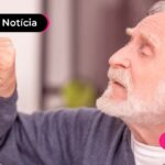 Imagem mostra pessoa de idade olhando para um calendário pendurado na parede.