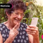 imagem de pessoa idosa olhando para o celular sorrindo