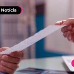 Imagem mostra pessoa de jaleco entregando um papel.
