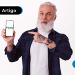 Imagem de idoso apontando para um celular com a ilustração "FGTS" na tela.